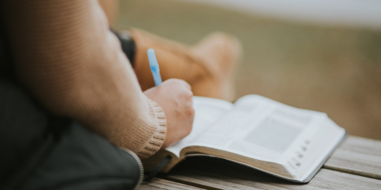 close-up photography of person writing on book page