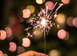 bokeh photography of person holding fireworks