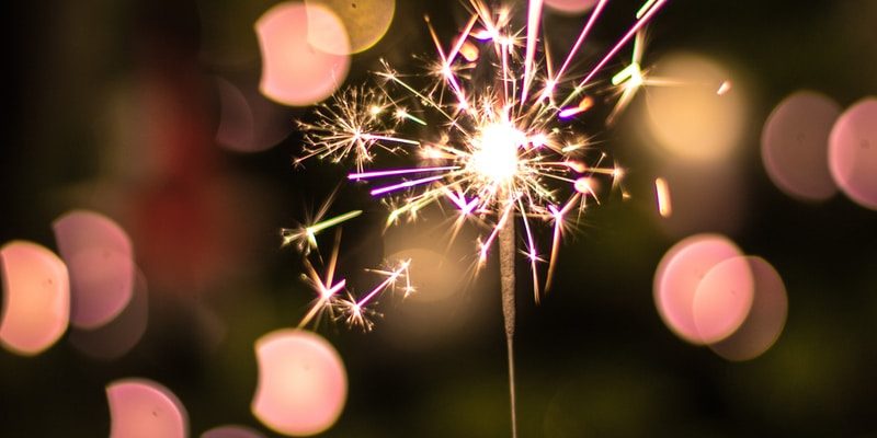 bokeh photography of person holding fireworks
