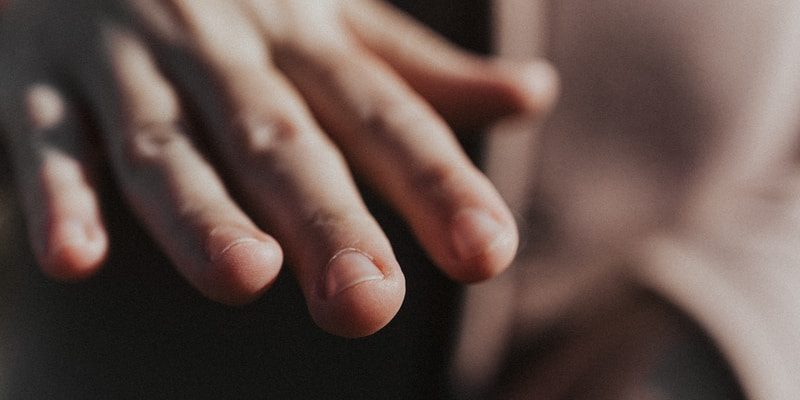 person in black pants showing left hand