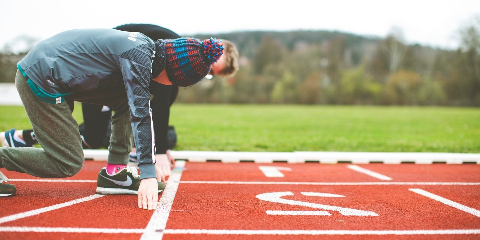 Photo by Markus Spiske man in black and red plaid shirt and black pants standing on track field during daytime