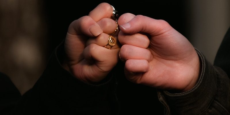 Photo by Taylor Smith person holding gold ring in dark room